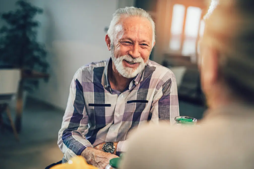 older man sitting and smiling during conversation