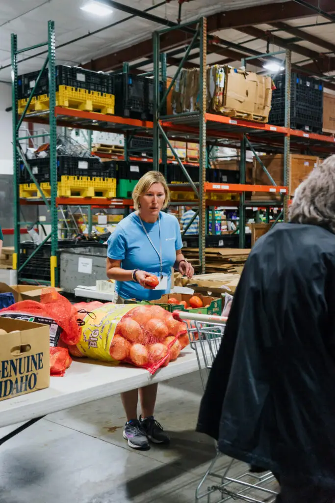 woman sorting through food donations in warehouse