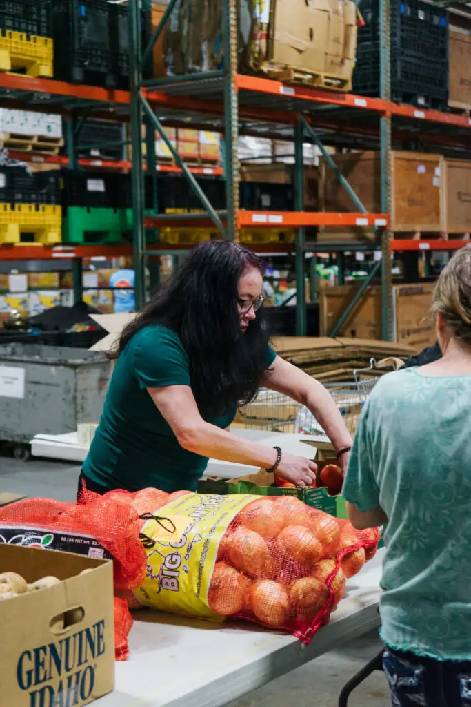 volunteer sorting through food donations in warehouse