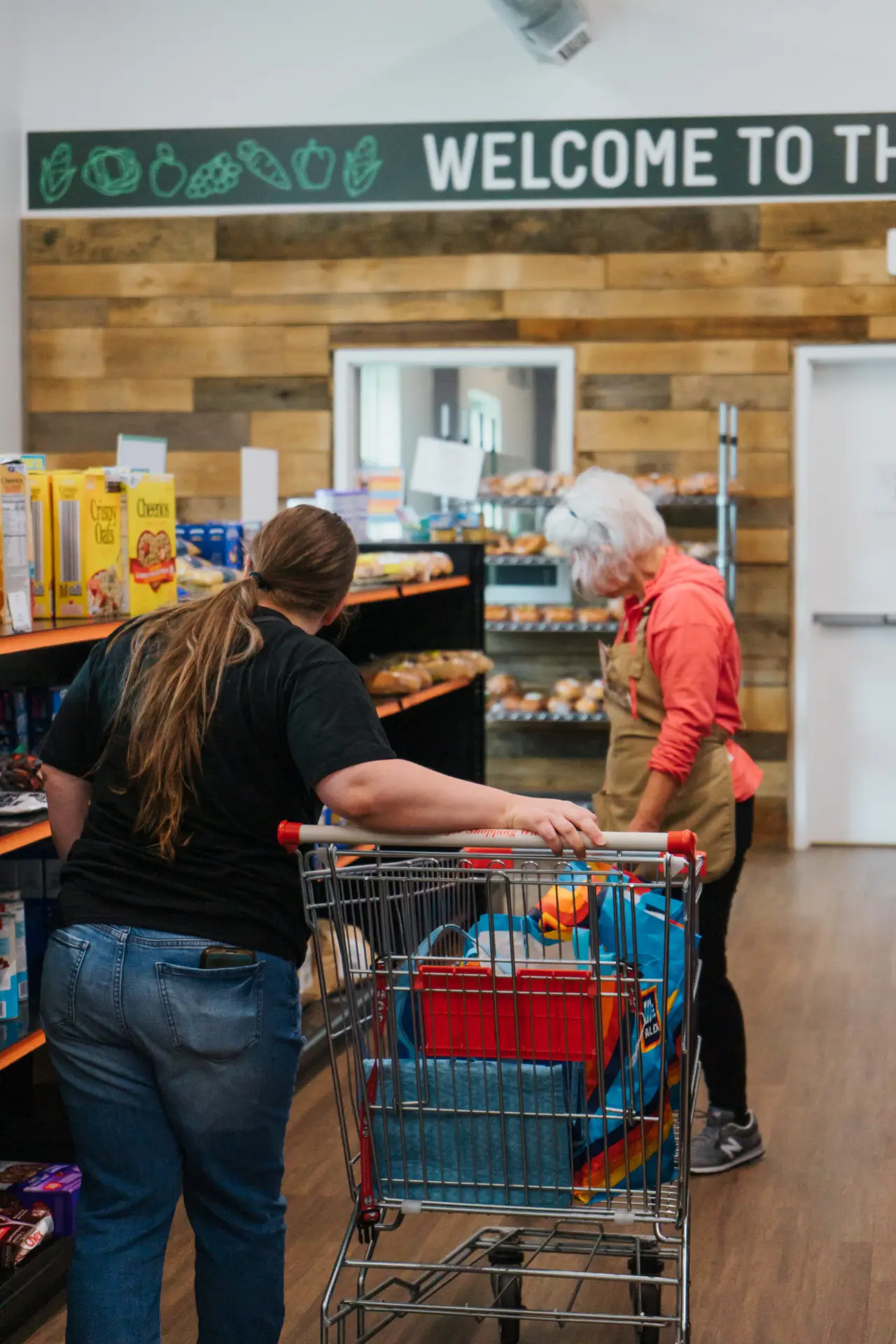 woman helping younger woman in food pantry