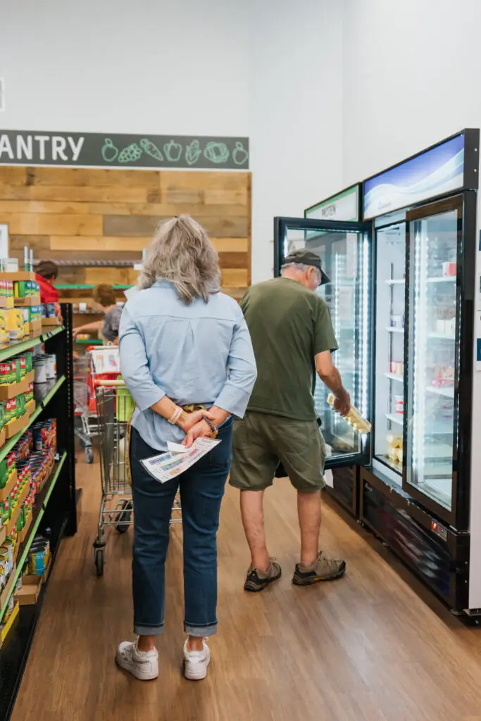 woman helping man in food pantry
