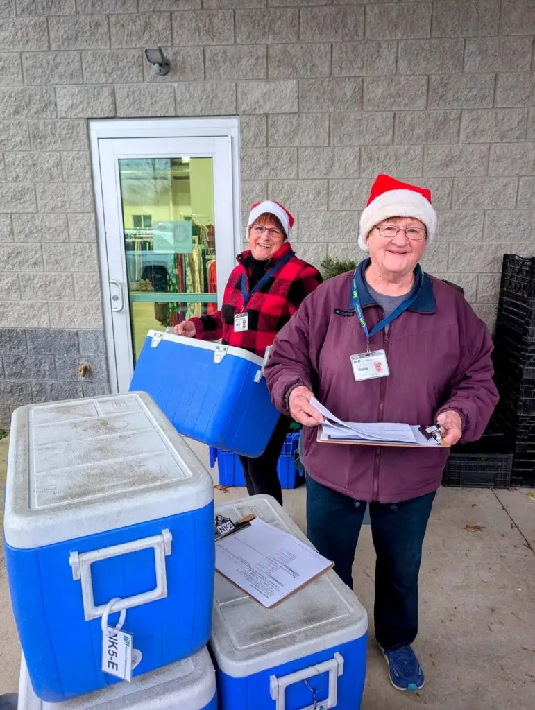 volunteers wearing santa hats and organizing coolers